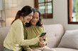 © NanSan - Mature asian mom with daughter on video call to parents, loving mother day concept.