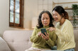 © NanSan - Mature asian mom with daughter on video call to parents, loving mother day concept.