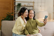 © NanSan - Mature asian mom with daughter on video call to parents, loving mother day concept.