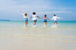 © SKW - Photo of a group of girls of different ethnicities running and having fun together at the beach. on a fresh day