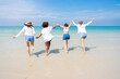 © SKW - Photo of a group of girls of different ethnicities running and having fun together at the beach. on a fresh day