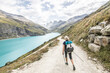 © Cavan Images - Senior hiker near reservoir in Swiss Alps,Â HauteÂ Route Traverse,Â ValaisÂ Canton, Switzerland