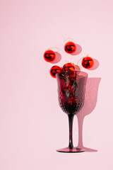 Minimal style, red new year decoration in glass, on pink background.