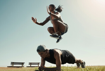 Canvas Print - Man, black woman and fitness in park, nature garden or sustainability environment for workout, training or exercise. Jumping, plank and sports people, friends or couple with energy and wellness goals