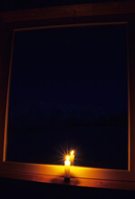 Lone Candle In Dark Window.