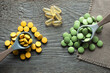 Dietary supplements from natural ingredients with natural plant extracts, yellow and green pills and medicines on a wooden background