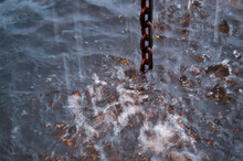 Close Up Of Rain Drops Collecting From A Chain Into A Barrel In Colorado.