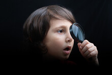 Portrat Of A Young Boy Looking Through The Magnifying Glass