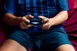 © Cavan Images - Close-up of a person playing the game console in the quarantine period