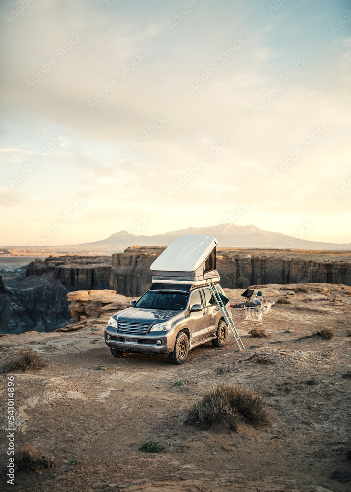 4x4 Vehicle with rooftop tent camping in desert at sunset Stock Photo ...