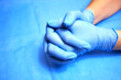 Hands of a medic in blue protective gloves close-up