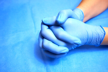 Hands of a medic in blue protective gloves close-up