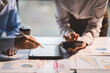© Daenin - Young colleagues discuss business and analytical price charts using calculators and laptops to calculate financial, tax, accounting, statistics and analytical research ideas.