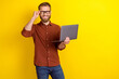 © deagreez - Photo of satisfied positive glad man blond beard dressed burgundy shirt hold laptop touch glasses isolated on yellow color background