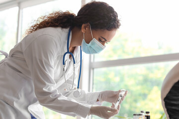 Poster - Female doctor in medical mask with syringe and ampule at hospital