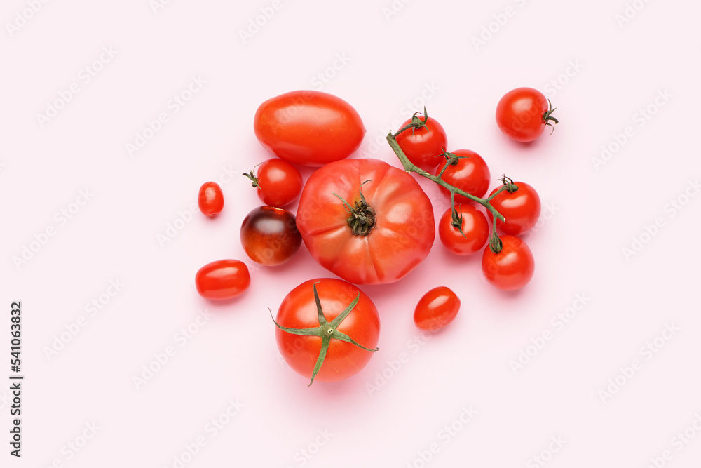 Heap of ripe tomatoes on pink background