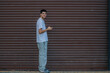 © carballo - young man with mobile phone in the street full body