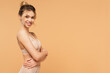 © LIGHTFIELD STUDIOS - happy young woman in lingerie standing with crossed arms and looking at camera isolated on beige