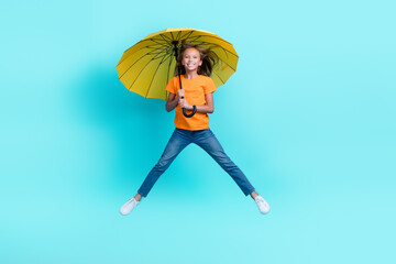 Sticker - Full body size photo of charming excited positive carefree preteen girl jumping flying windy air parasol enjoy isolated on aquamarine color background