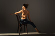 © LIGHTFIELD STUDIOS - back view of half nude barefoot woman in jeans posing on wooden chair on grey background with lighting