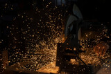 Fototapeta  - Sparks from metal. Cutting steel. Saw spins quickly. Industrial background.