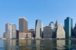 Lower Manhattan NYC skyline with still reflective water, seen from the East River