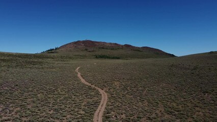 Poster - aerial view of a dirt road leading up a mountain in the desert