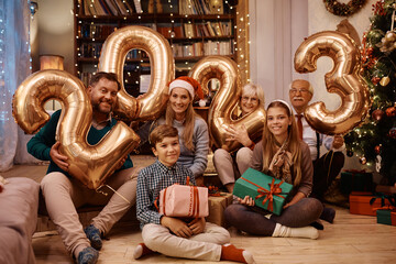 Wall Mural - Portrait of happy extended family on New Year's day at home looking at camera.