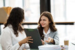© PaeGAG - Young friendly business people are talking to each other, while sitting at the desk in a modern office. Focus on woman. Concept of business success