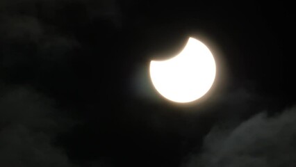 Wall Mural - partial solar eclipse with a small thin layer of clouds moving across the sky - oct. 25, 2022