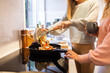 © Austockphoto - Two women in the kitchen cooking together, serving dinner