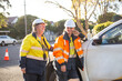 © Austockphoto - Two smiling women road workers with white helmet and high vis workwear leaning on a white car