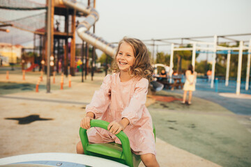 Wall Mural - Cute little girl playing on the playground.