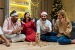© Liubomir - New year party, various friends at home on floor playing game, men and women smiling and happy together for christmas spend time.