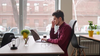 Wall Mural - young freelancer man working with laptop at bright spacious coworking alone. creative designer manag