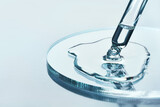 Pipette with sample of cosmetic product in petri dish on blue background, selective focus