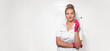 © Chiralli - Portrait of woman doctor dentist over white ceramic tile wall of medical office dentistry. Medic in pink gloves holds dental tools. Positively looking at camera. Wide banner with copy space, mock up.
