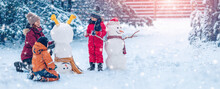 Family Bilding A Cute Snowman In The Snowy Park.