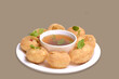 Delicious north and south indian street food pani puri gol gappa with tamarind water served in white plate and potato and chickpeas
