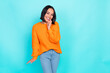 Photo of adorable sweet pleasant girl with straight hairdo dressed orange pullover finger on teeth isolated on teal color background