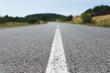 © madrolly - White dividing line on asphalt in nature. Road between hills or mountains
