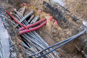 Connecting fiber optic internet connection network cables. Upgrade infrastructure in the city. Construction site with a lot of high speed communication cables buried underground in the street.