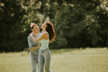 Wall Mural - Happy young couple in love at the grass field