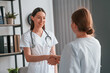 © standret - Young doctor in white coat is with female patient in the office