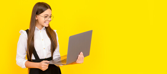 Wall Mural - cheerful child study online. computer vision syndrome. nerd typing school blog. School girl portrait with laptop, horizontal poster. Banner header with copy space.