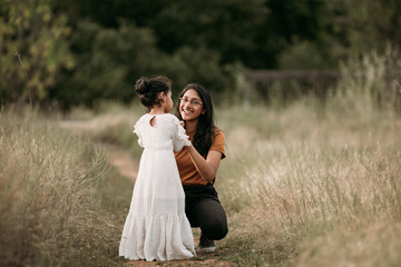 Wall Mural - Sisters smiling and holding hands in a field 