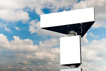 Wall Mural - two blank white billboards or large displays against blue sky with white clouds - mock up. consumeri