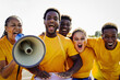 © Vane Nunes - Crazy African football fans celebrating in the crowd watching the game at sport stadium - Soccer supporters shouting for yellow team during world champion event - Focus on senior woman face