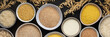 Various grain cereals in bowls banner, top view on a brown background with bowls of cereals and ears of oats