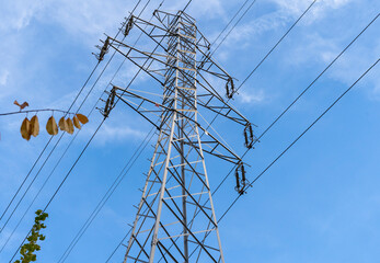 Electric station for supplying electricity to city, village. High voltage electric tower. Close-up. Power line against blue sky.